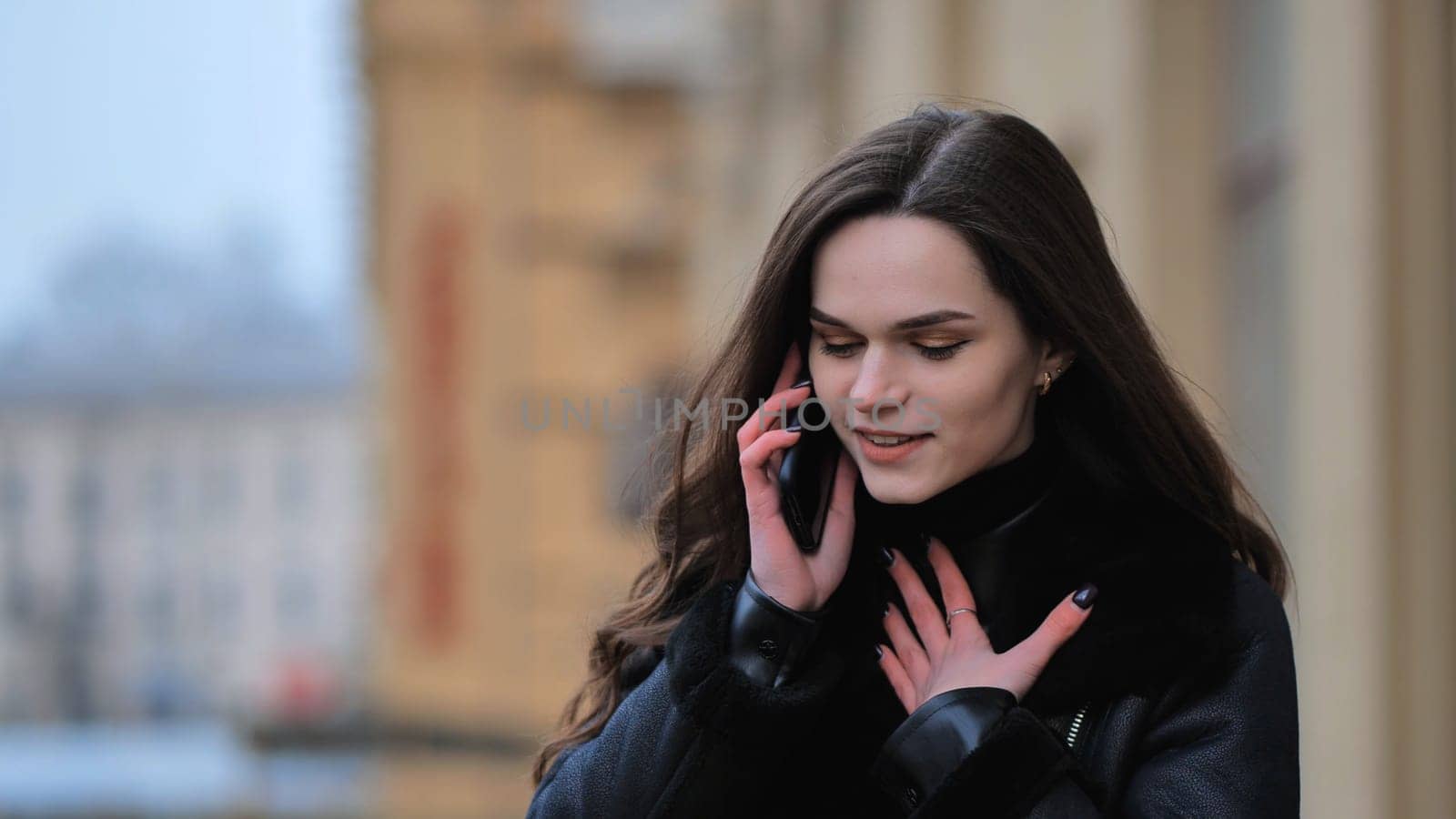 Beautiful stylish brunette girl talking on the phone on the street of her city