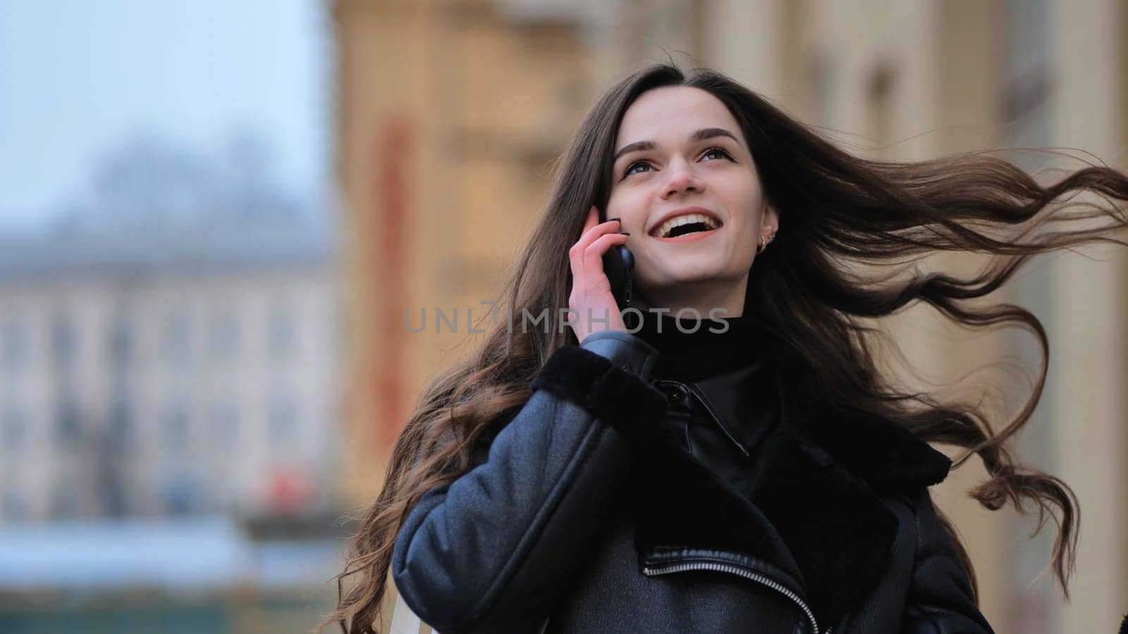 Beautiful stylish brunette girl talking on the phone on the street of her city