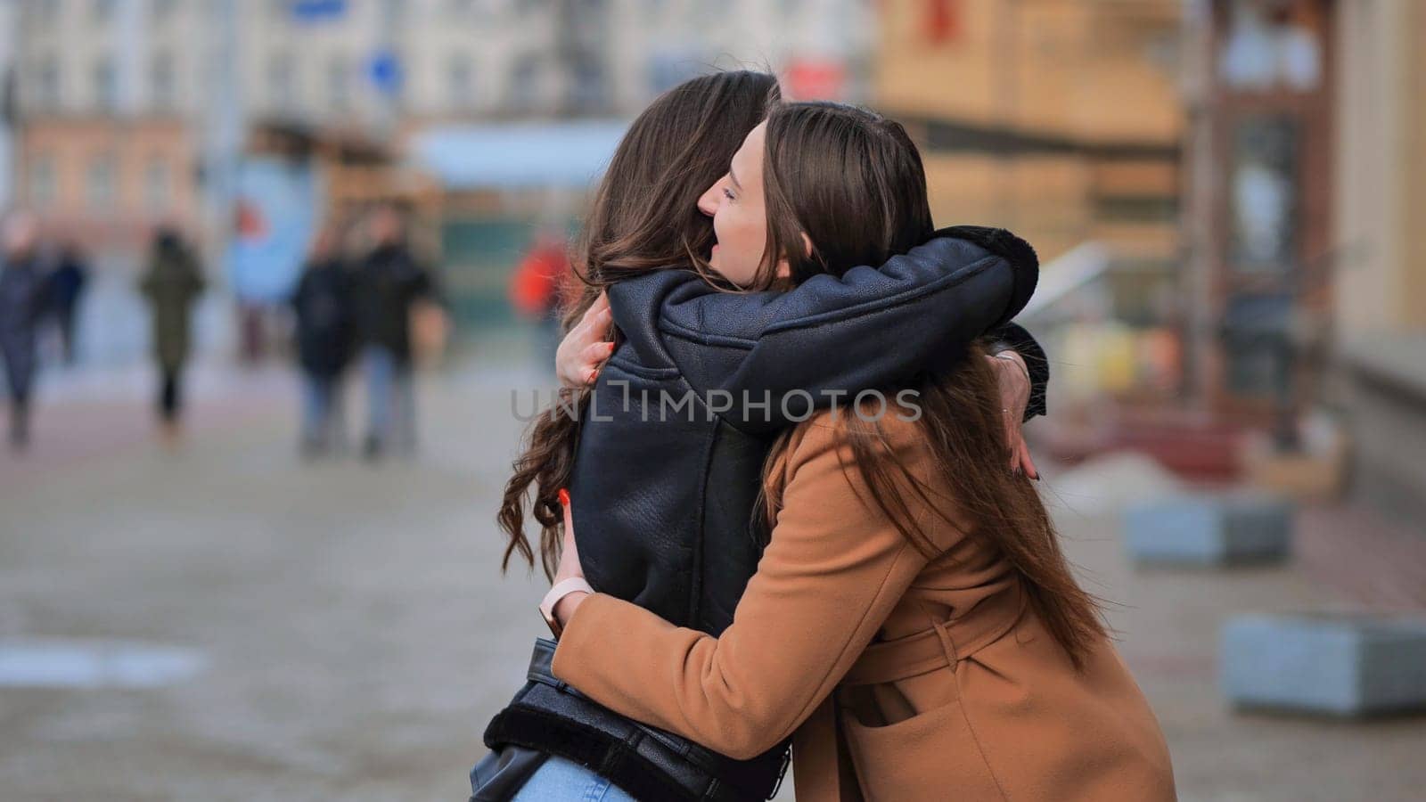 Two best friends meet on the streets of the city and hug