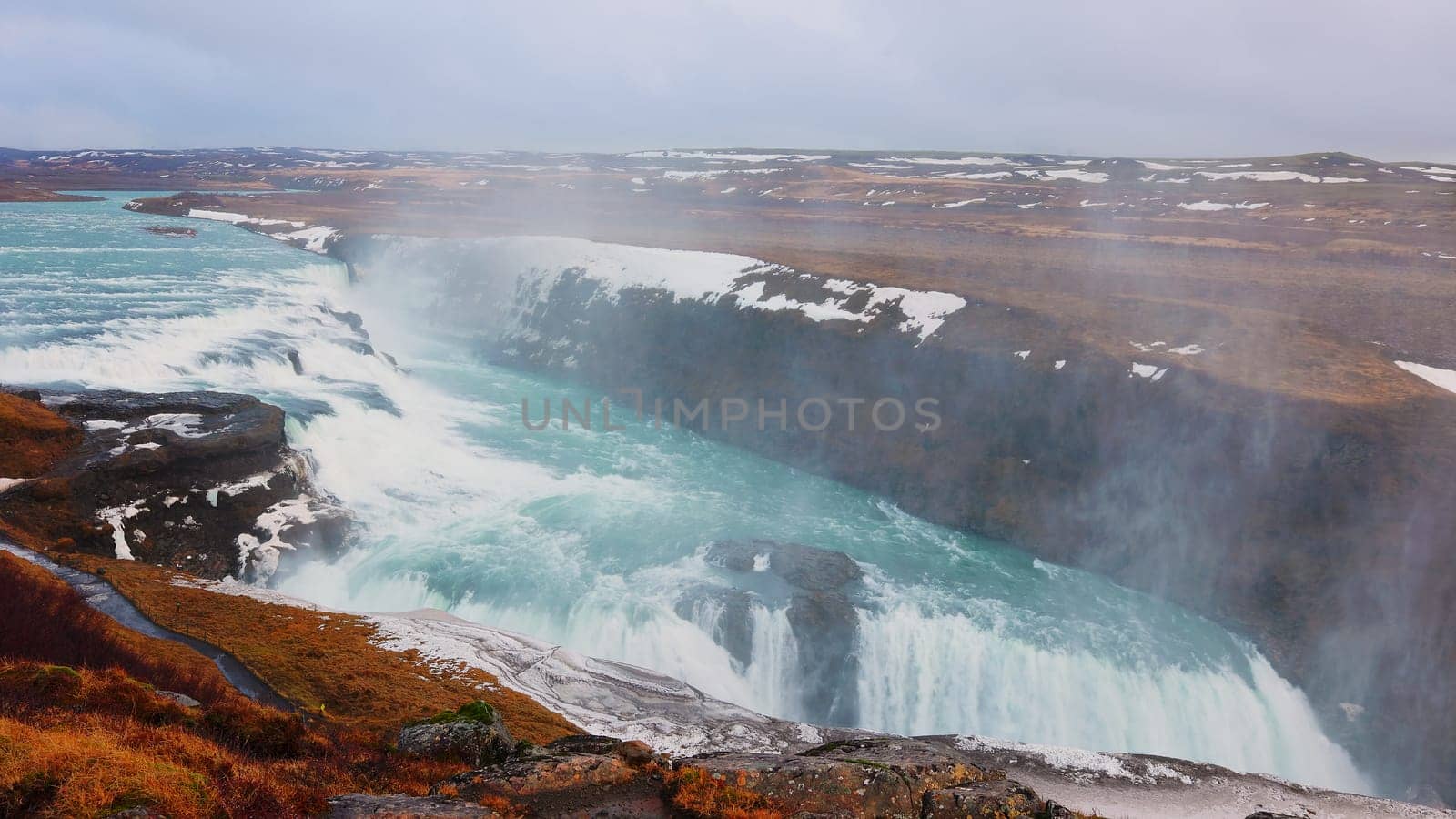 Gullfoss waterfall in reykjavik iceland, spectacular nordic landscape with snow and cold water falling off cliff. River scenery on top of the hill, icelandic nature with cascade. Handheld shot.