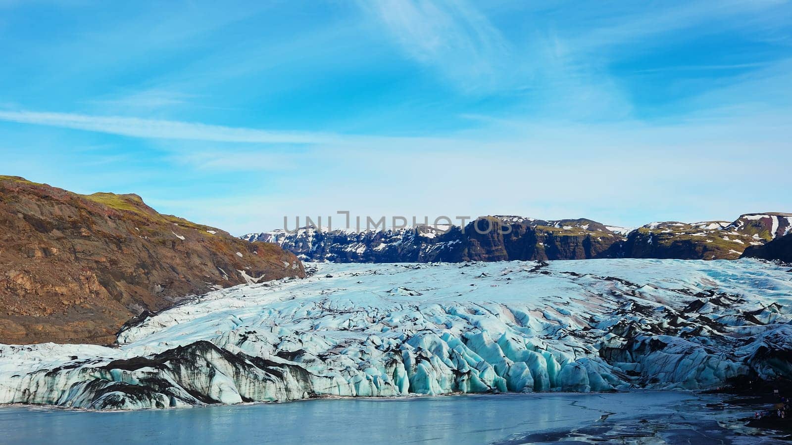 Vatnajokull glacier covered in frost in iceland, spectacular massive icebergs colored with white and blue. Frozen cold ice cap in icelandic winter landscape and arctic snowy mountains.