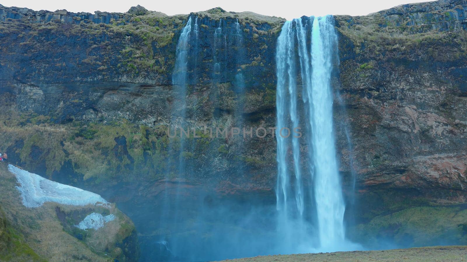 Seljalandsfoss waterfall in iceland circa March 2023 with beautiful nordic landscapes. Water flow falling down off cliff in reykjavik, majestic natural cascade stream off hills. Handheld shot.
