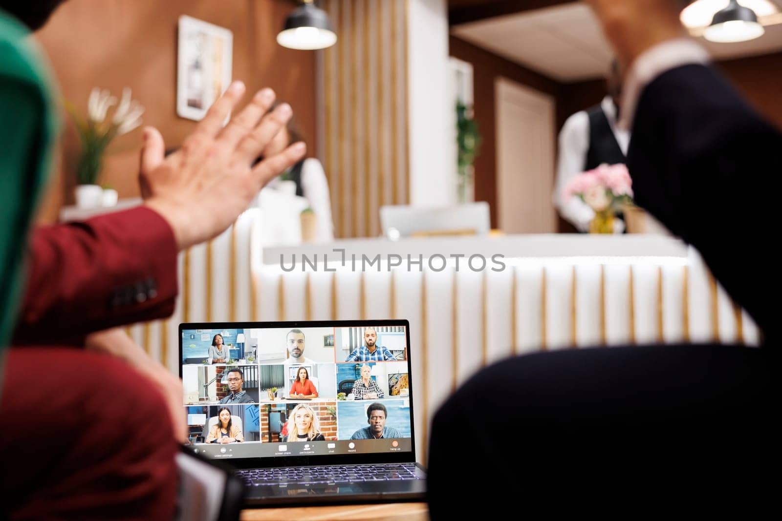 Two employees using videocall remote while they wait for room to be ready, attending business meeting teleconference. Entrepreneur talking to colleagues in hotel lobby, telework.