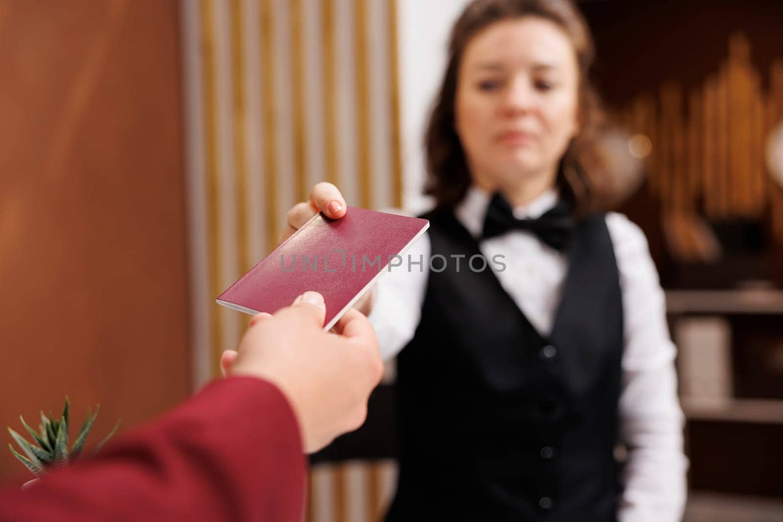 Receptionist asking for identification, taking passport from businessman to fill in registration forms and do check in procedure. Entrepreneur providing id documents. Close up.