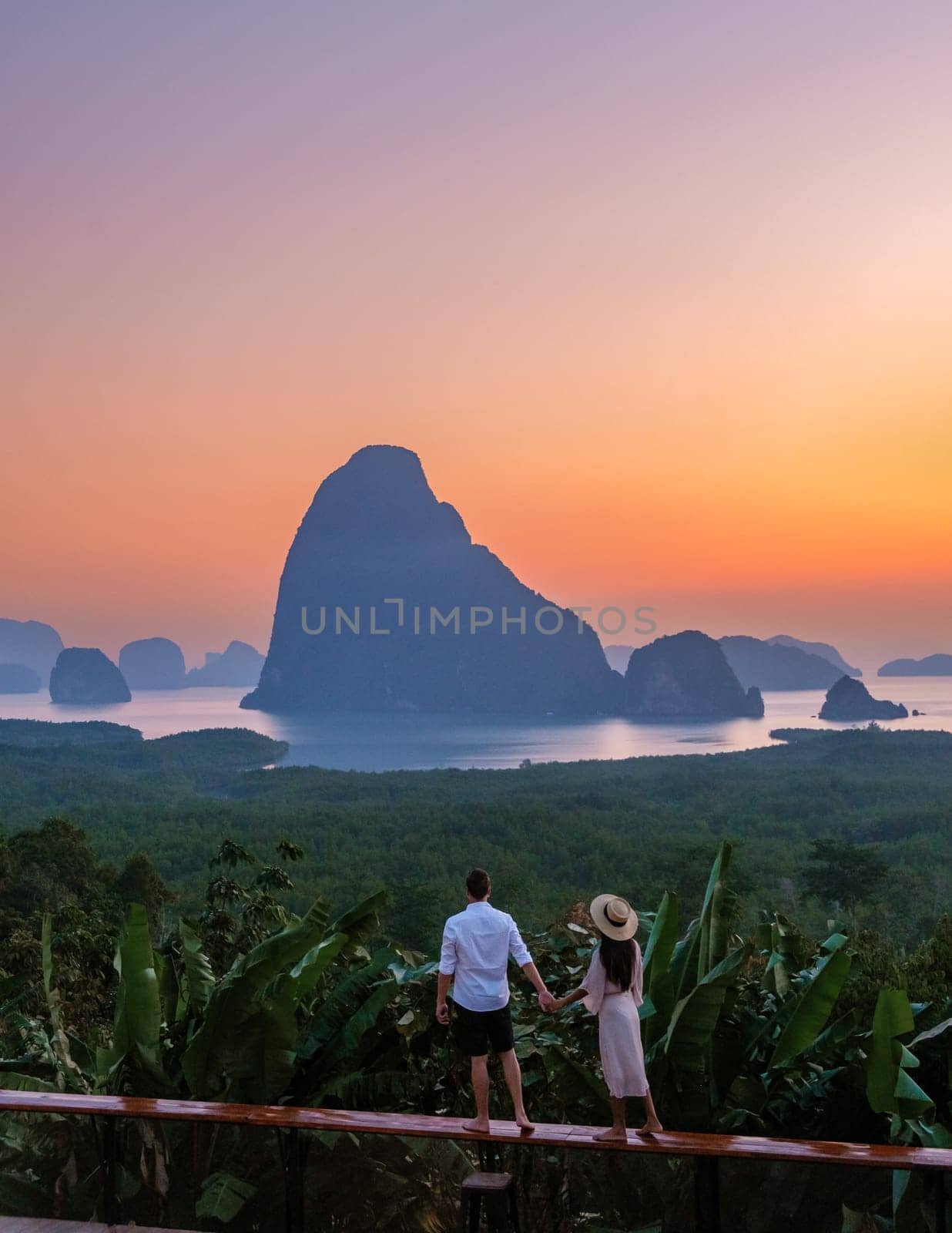 A couple of men and woman watching the sunrise at Sametnangshe viewpoint in Phangnga Bay Phangnga, Thailand