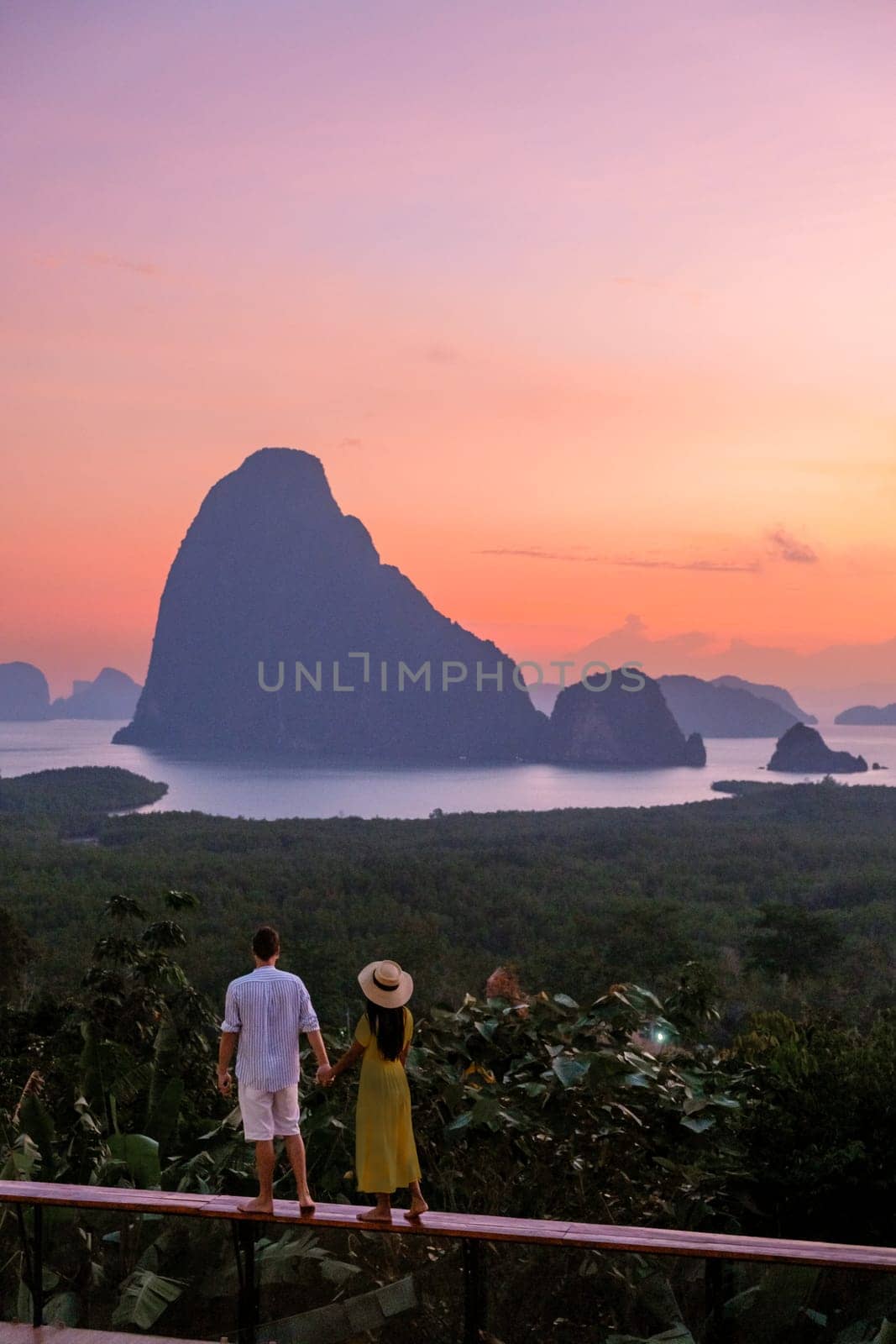 Couple watching sunrise at Sametnangshe viewpoint of mountains in Phangnga bay Thailand by fokkebok