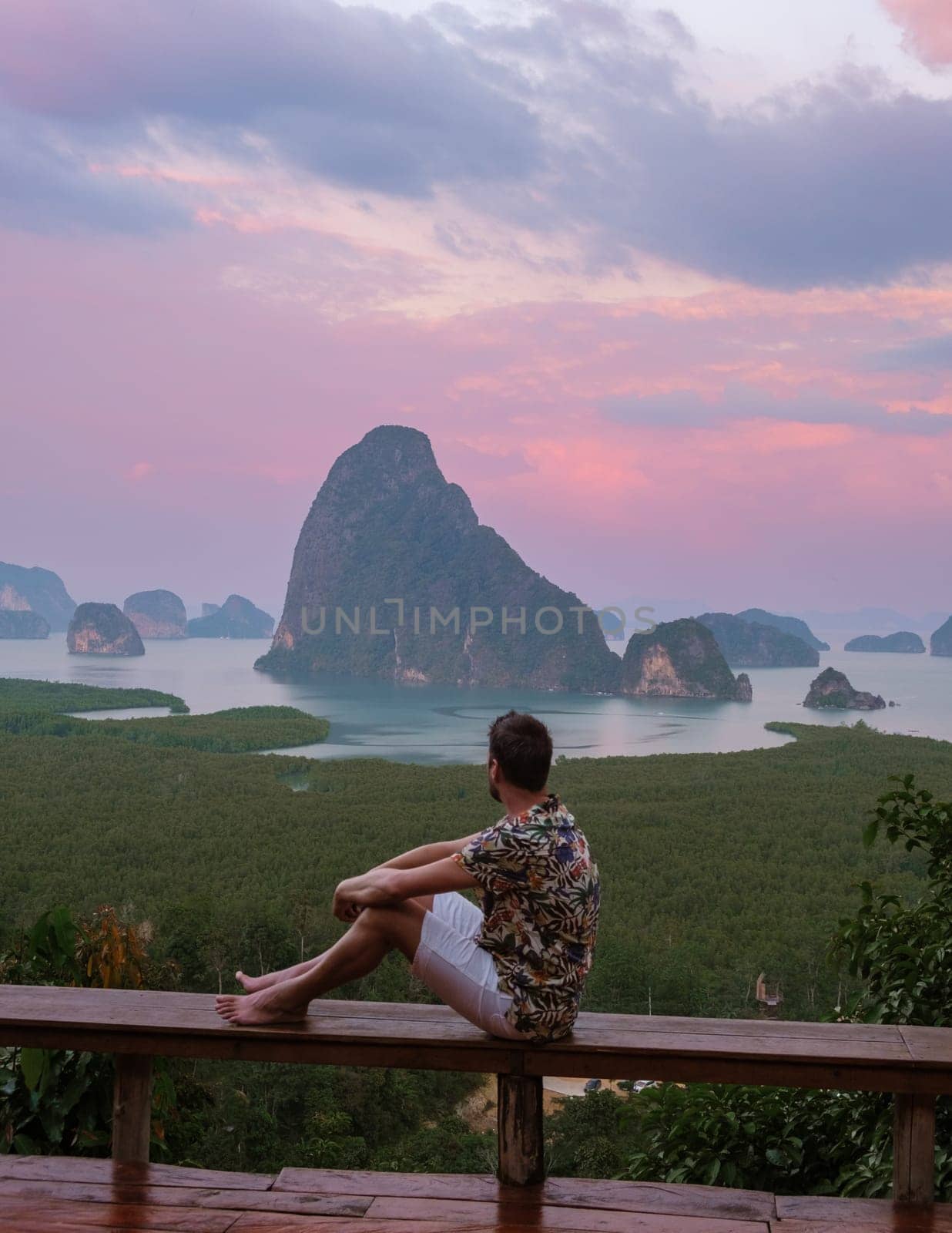 a man watching sunrise at Sametnangshe viewpoint of mountains in Phangnga bay Thailand by fokkebok