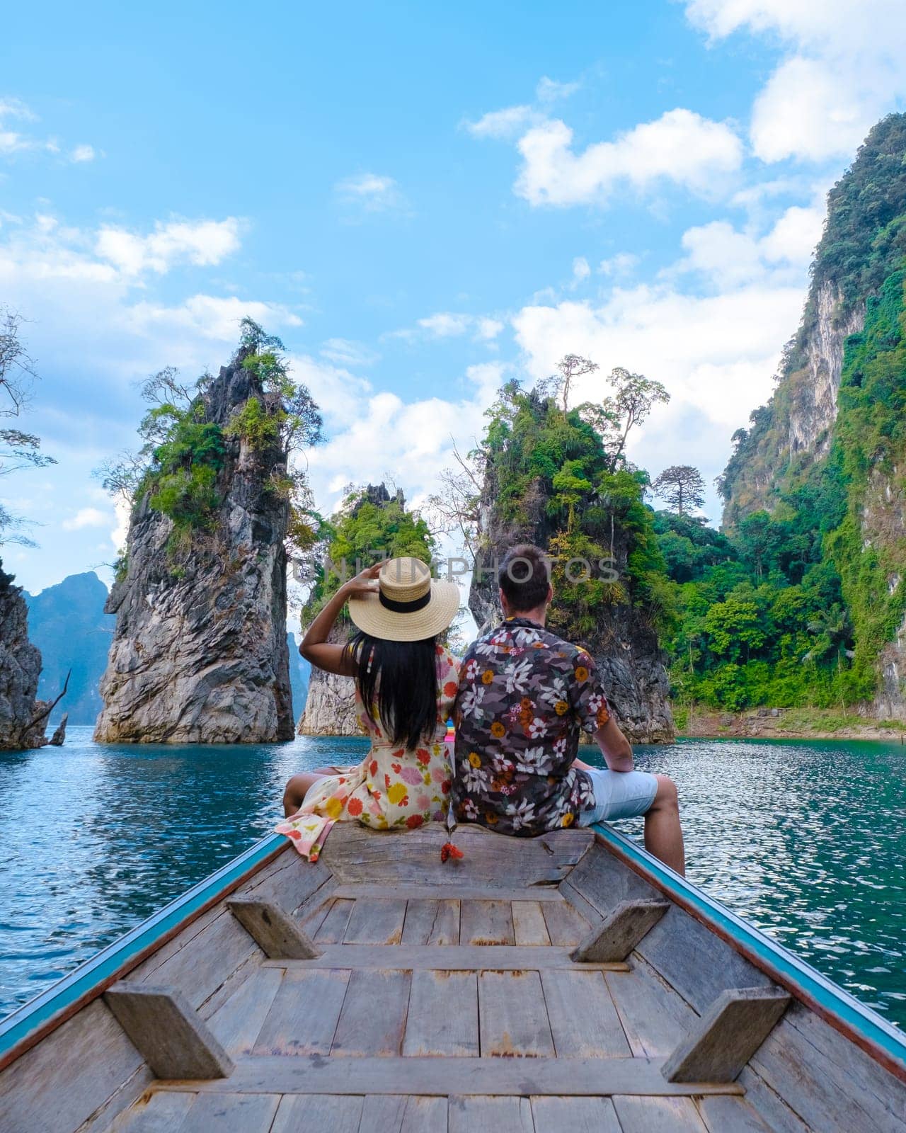 A couple of men and women in front of a longtail boat in Khao Sok Thailand, Scenic mountains on the lake in Khao Sok National Park South East Asia