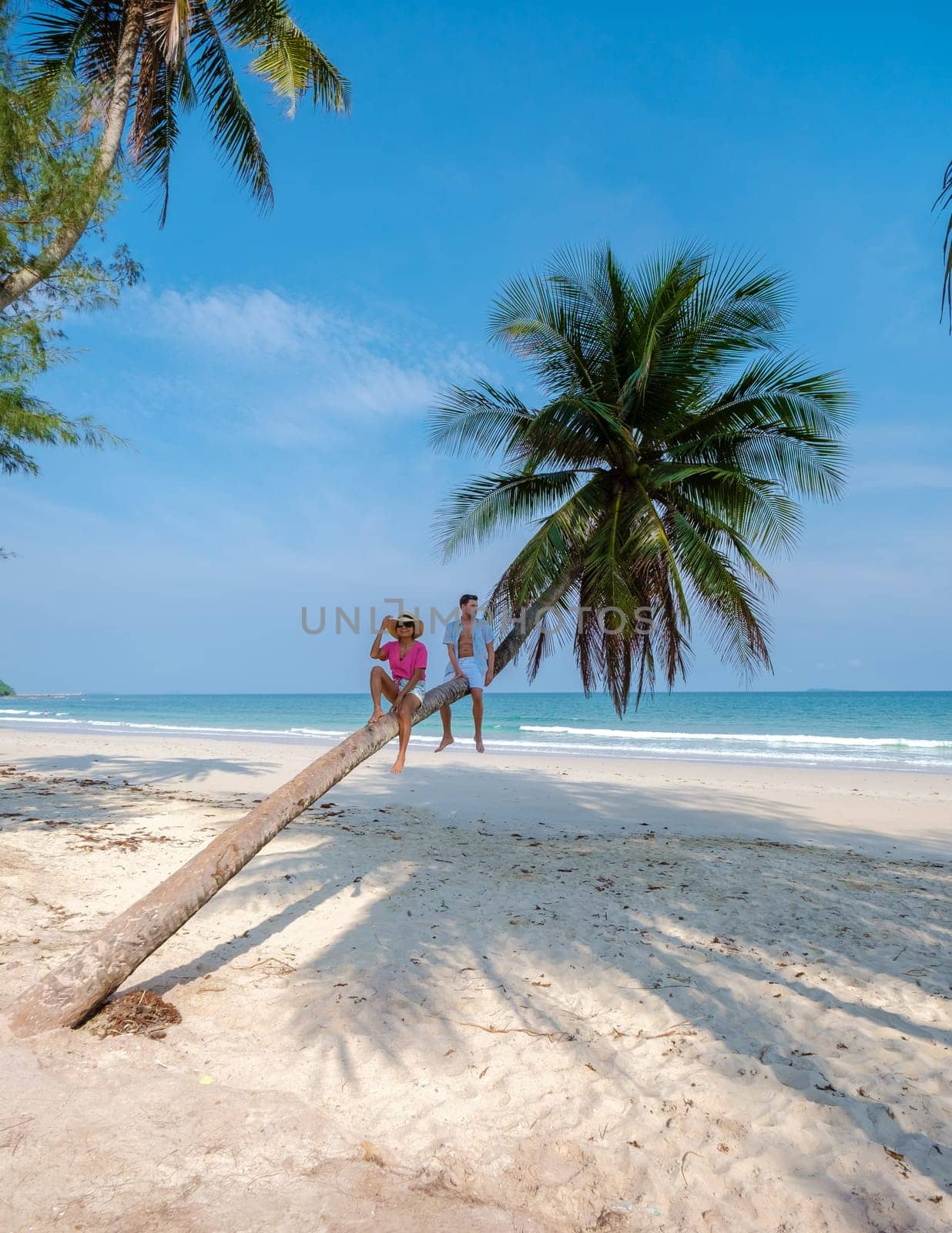 couple on vacation in Thailand Chumphon province walking at a white tropical beach with palm trees, Wua Laen beach Chumphon Thailand, palm tree hanging over the beach