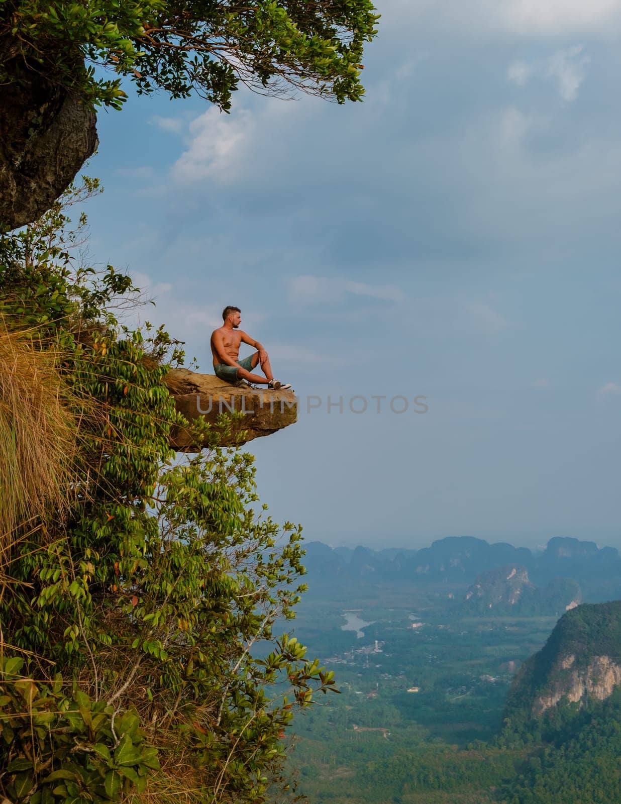 young men at the edge of a mountain, Dragon Crest mountain Krabi Thailand by fokkebok