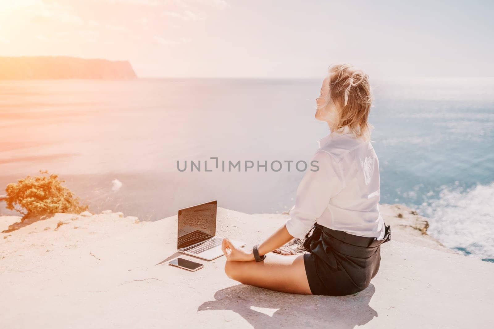 Woman sea laptop yoga. Business woman freelancer in yoga pose working over blue sea beach at laptop and meditates. Girl relieves stress from work. Freelance, digital nomad, travel and holidays concept by panophotograph