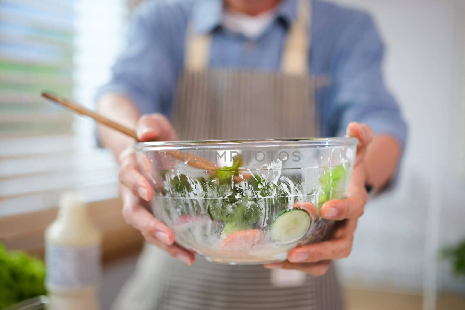 Closeup senior man holding bowl of healthy fresh vegetarian salad. Healthy food, dieting, vegan food concept