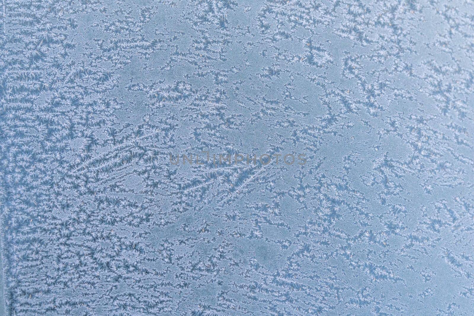 Selective focus. First frost on a frozen car, late autumn close-up. Beautiful abstract frozen microcosmos pattern. Freezing weather frost action in nature. Winter backdrop. by panophotograph