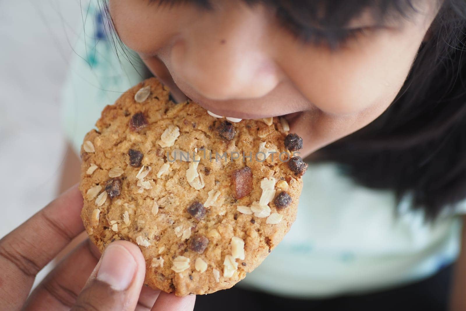closeup of child eating whole meal cookies ,
