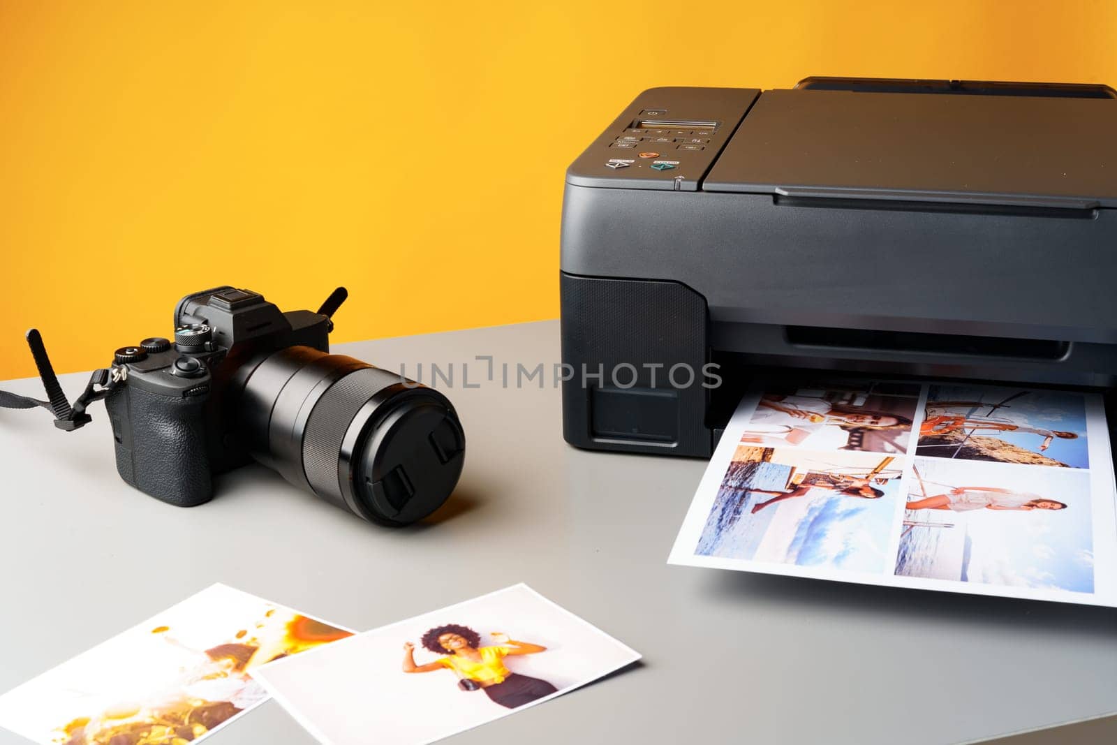 Printer printing colorful photos of people close up, yellow background, studio shot