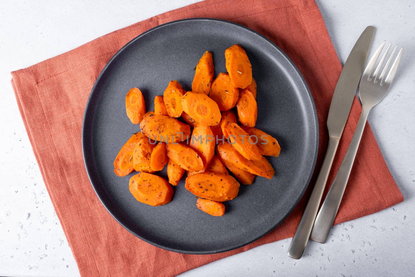 Baked carrots lie on a plate. Selective focus.