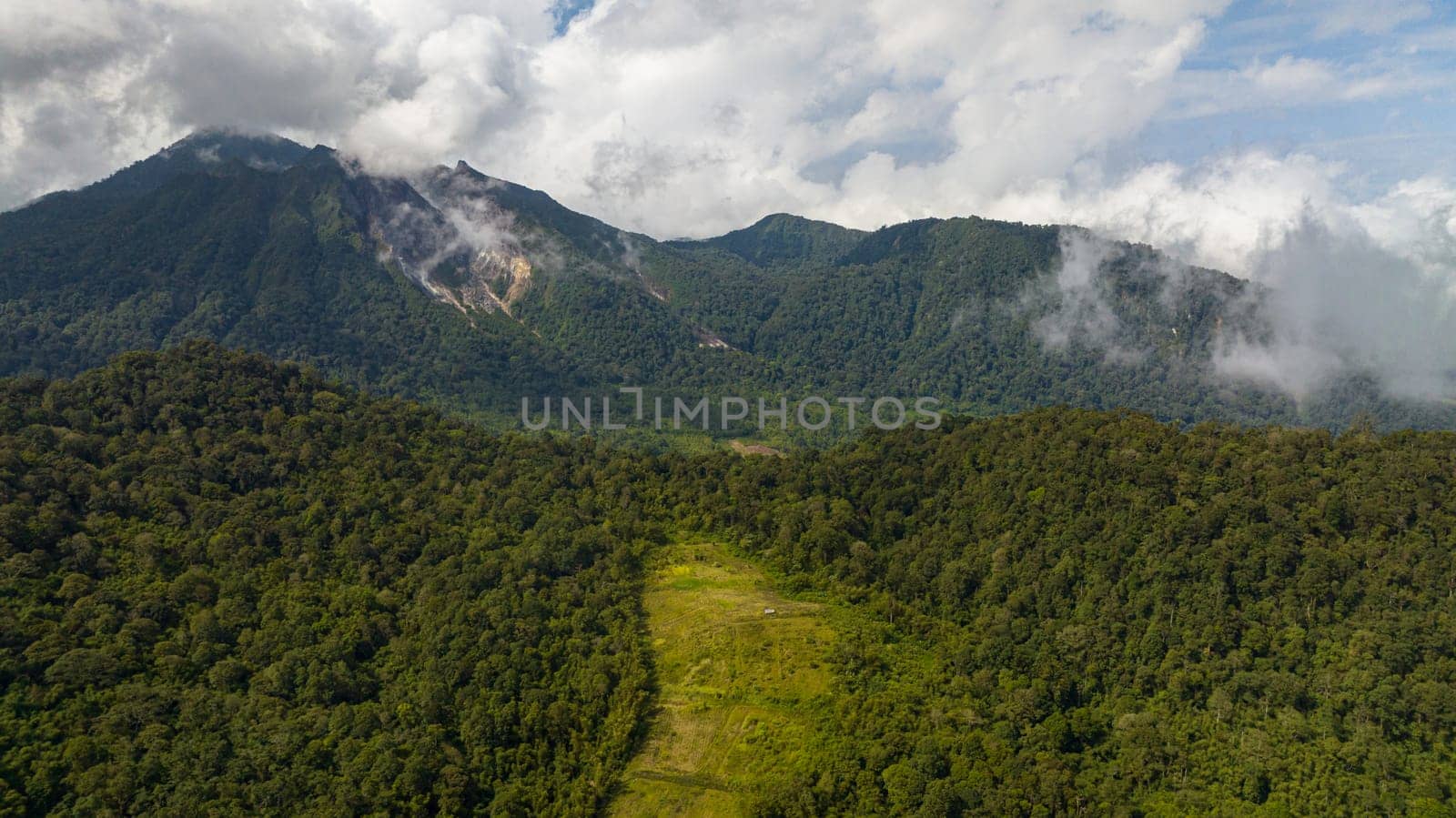 Top view of active Sibayak volcano and mountains with forest. Sumatra, Indonesia.