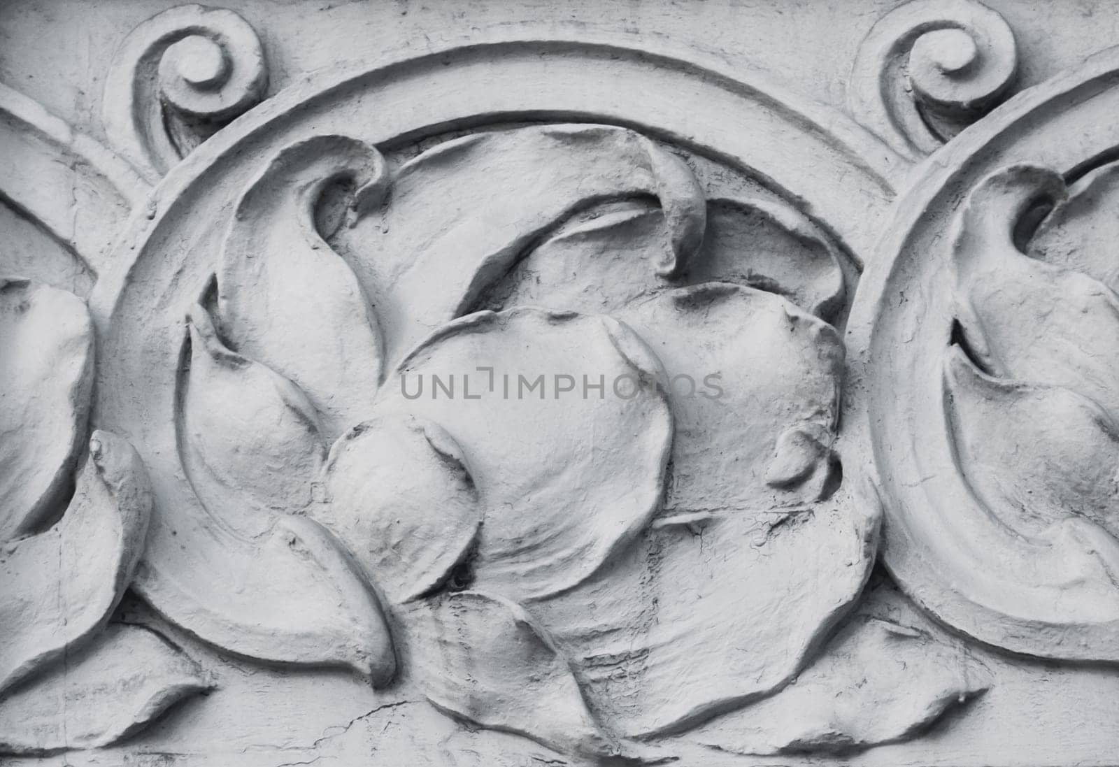 Close up carved flower on the wall concept photo. Bas-relief lotus wall decoration. Concrete wall texrture modeling. Stucco mouldings roccoco element
