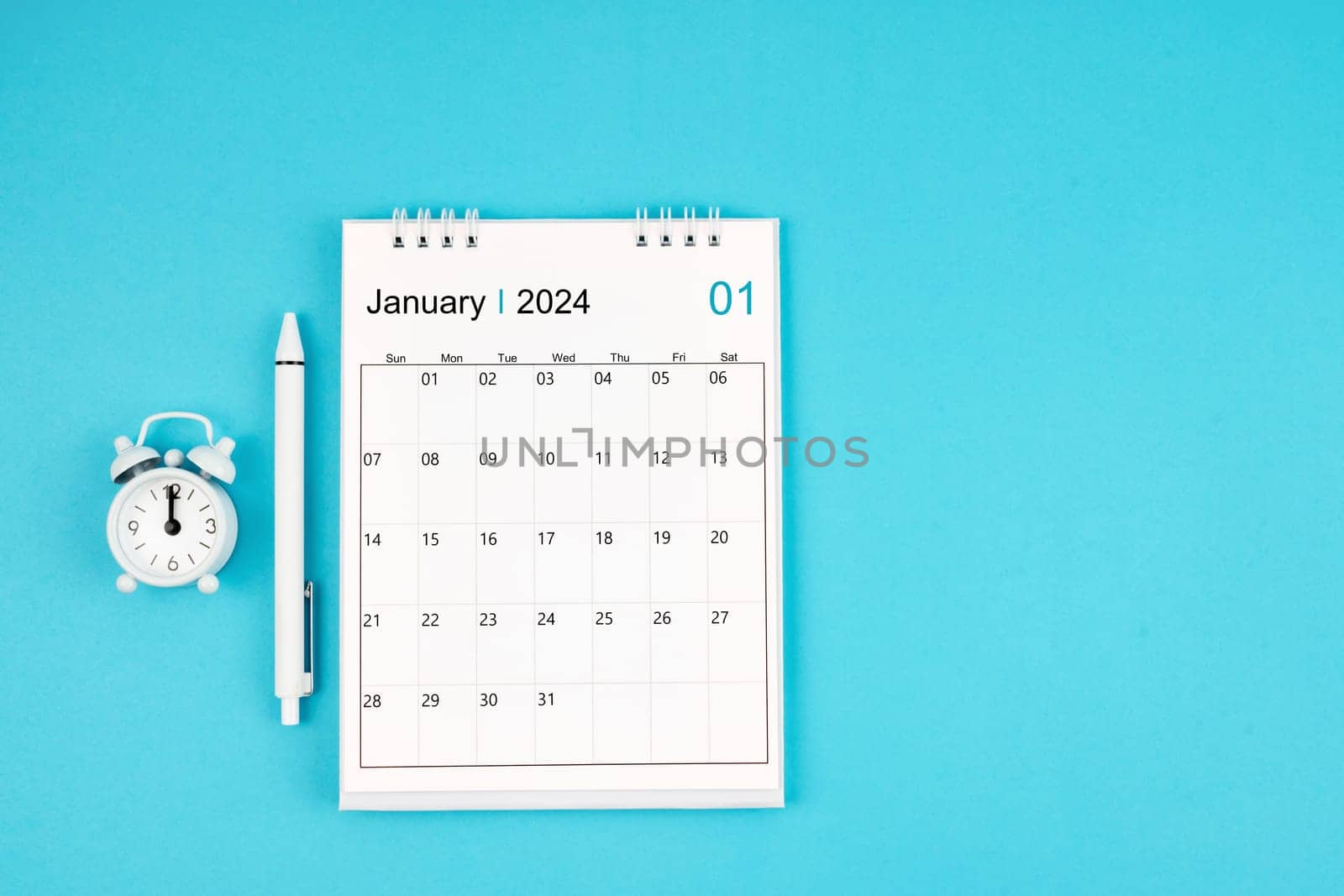 January 2024, Monthly desk calendar for 2024 year and pen with alarm clock on blue color background.
