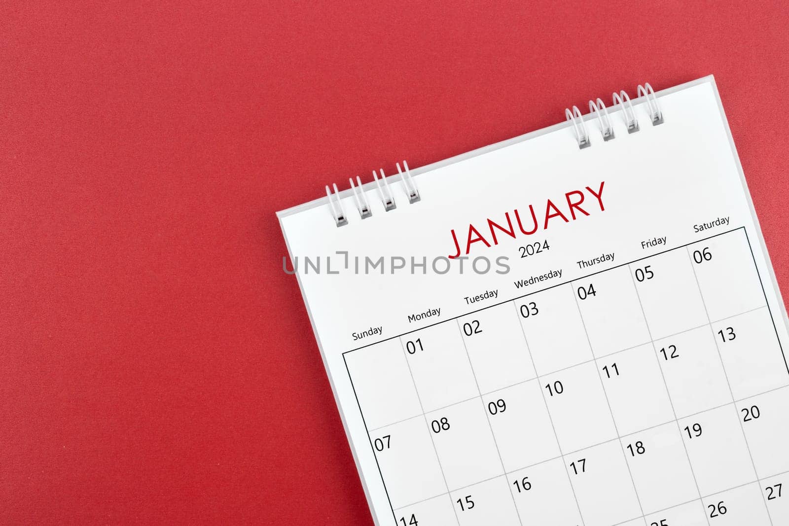 January 2024 desk calendar on red background. by Gamjai