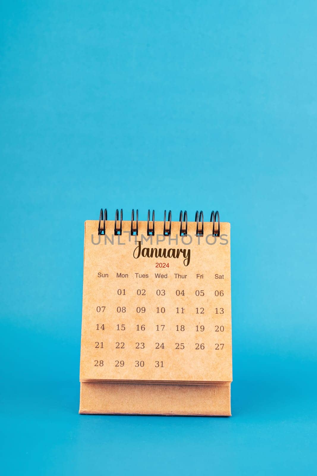 January 2024 white desk calendar on blue color background.