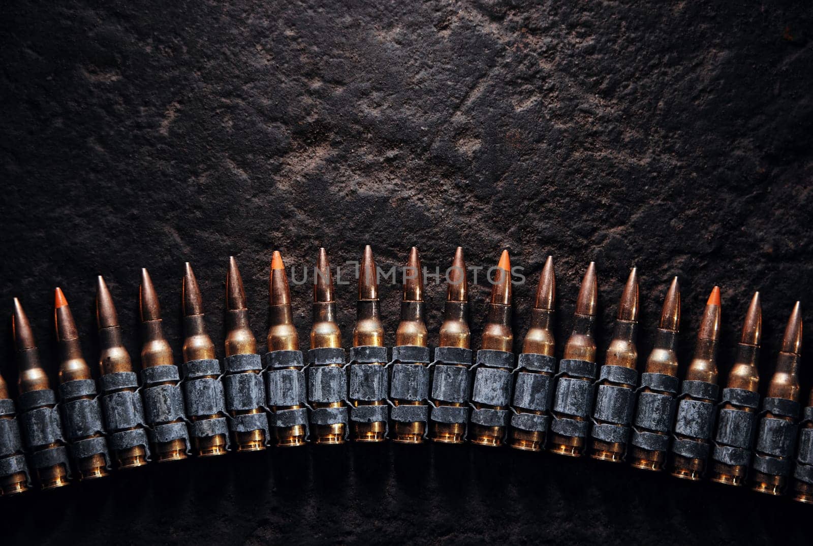 Machine gun bullet belt on the floor. Background on the military theme. Ammo, chain of ammo on concrete background. Top view of machine gun belt cartridge 7.62 mm caliber on dark background.