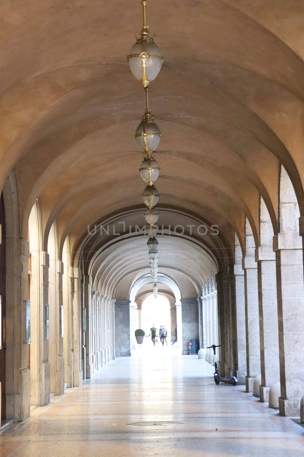 The arched yellow stone colonnade with lanterns concept photo. Urban architectural photography. High quality picture