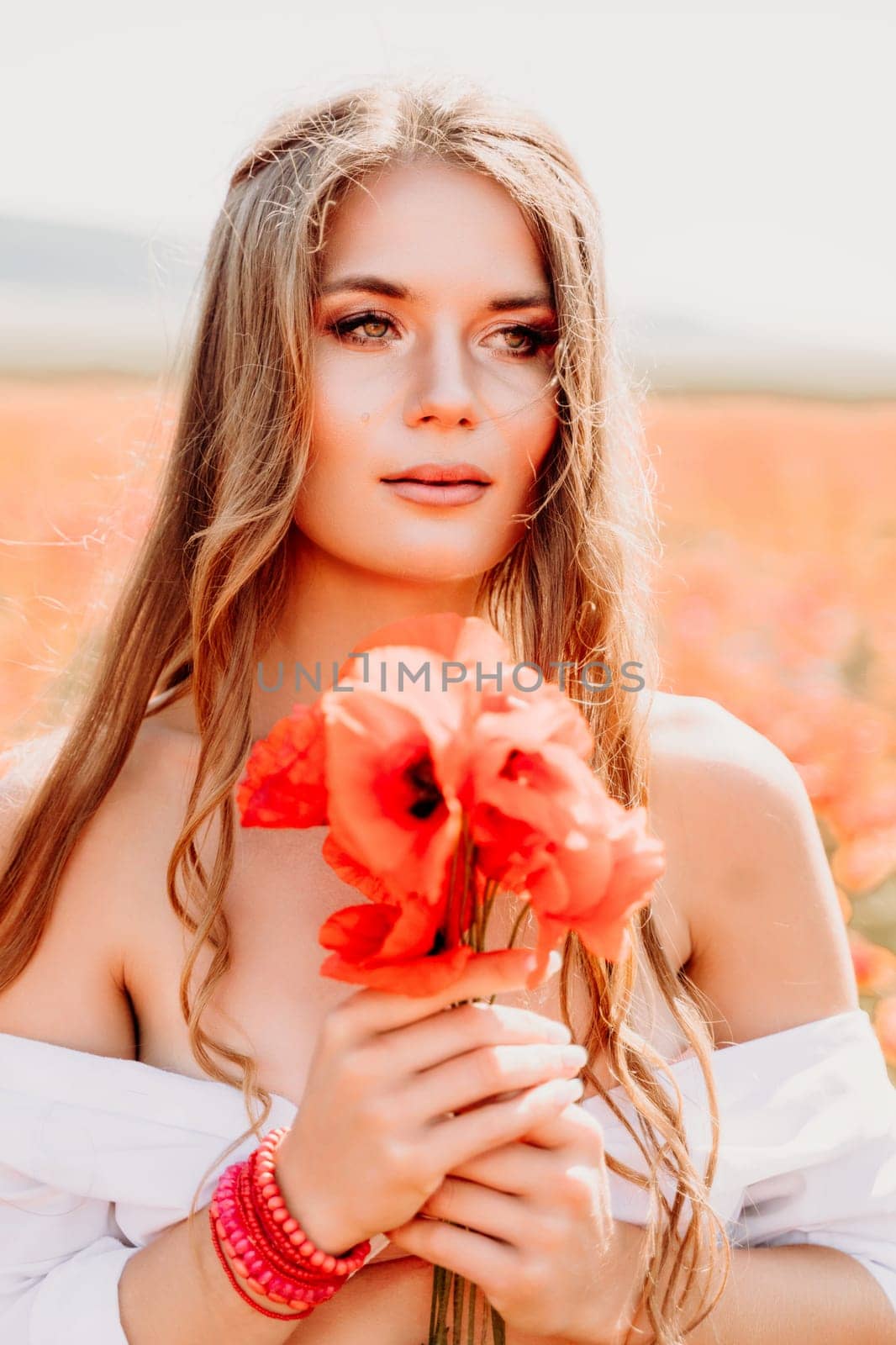 Woman poppies field. Side view of a happy woman with long hair in a poppy field and enjoying the beauty of nature in a warm summer day