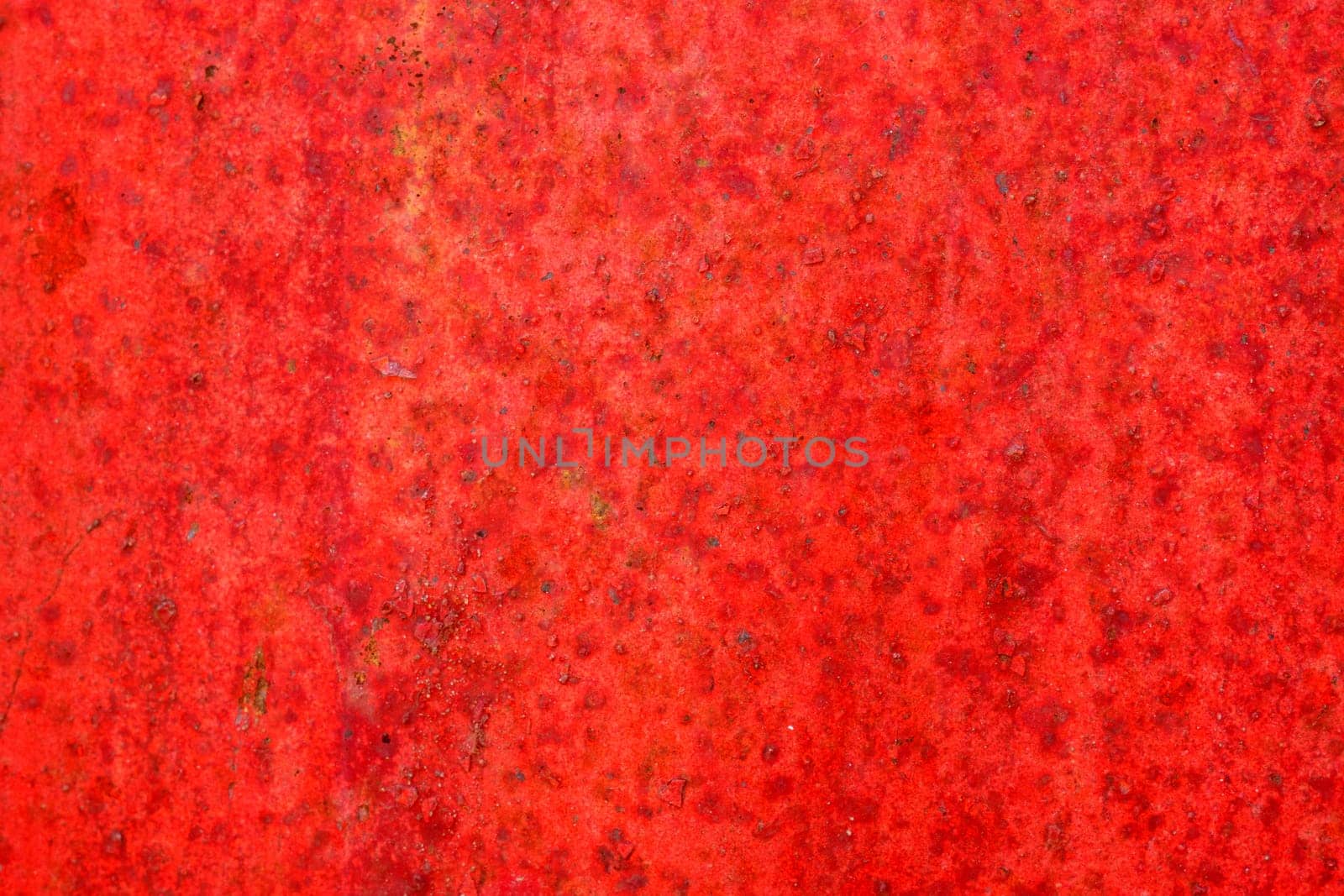 Red metal surface with spots creating textured wall background