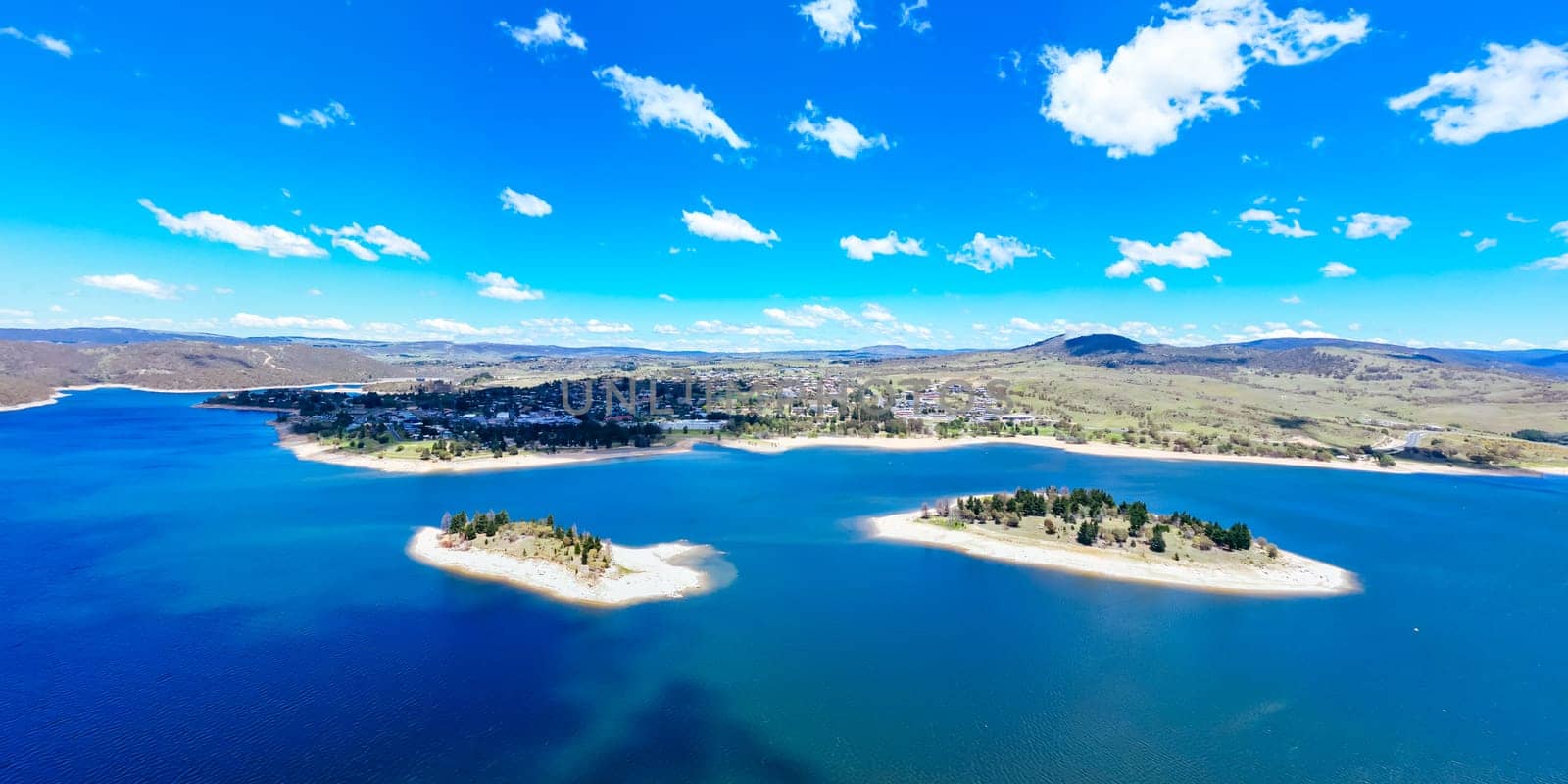 The view towards the town of Jindabyne over Lion and Cub Islands in Lake Jindabyne on a warm sunny summer's day in New South Wales, Australia