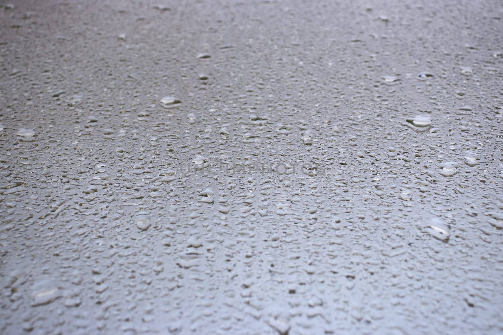 Close-up view on water drops on window in rain. Drops of rain on the glass concept photo. Front view photography with blurred background. High quality picture