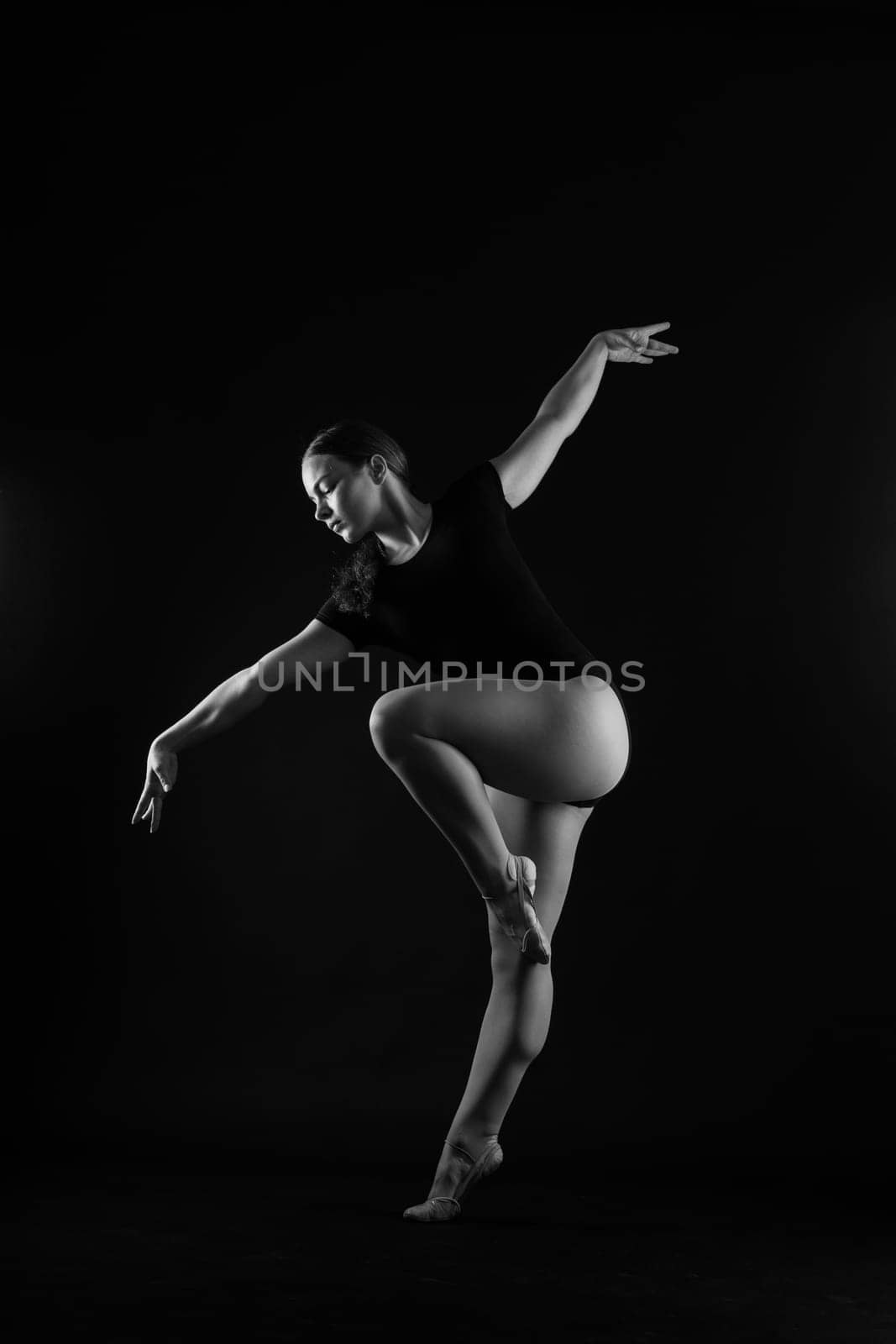 Gymnastics, woman acrobat, female gymnast strong flexible body over black and white backgrounds