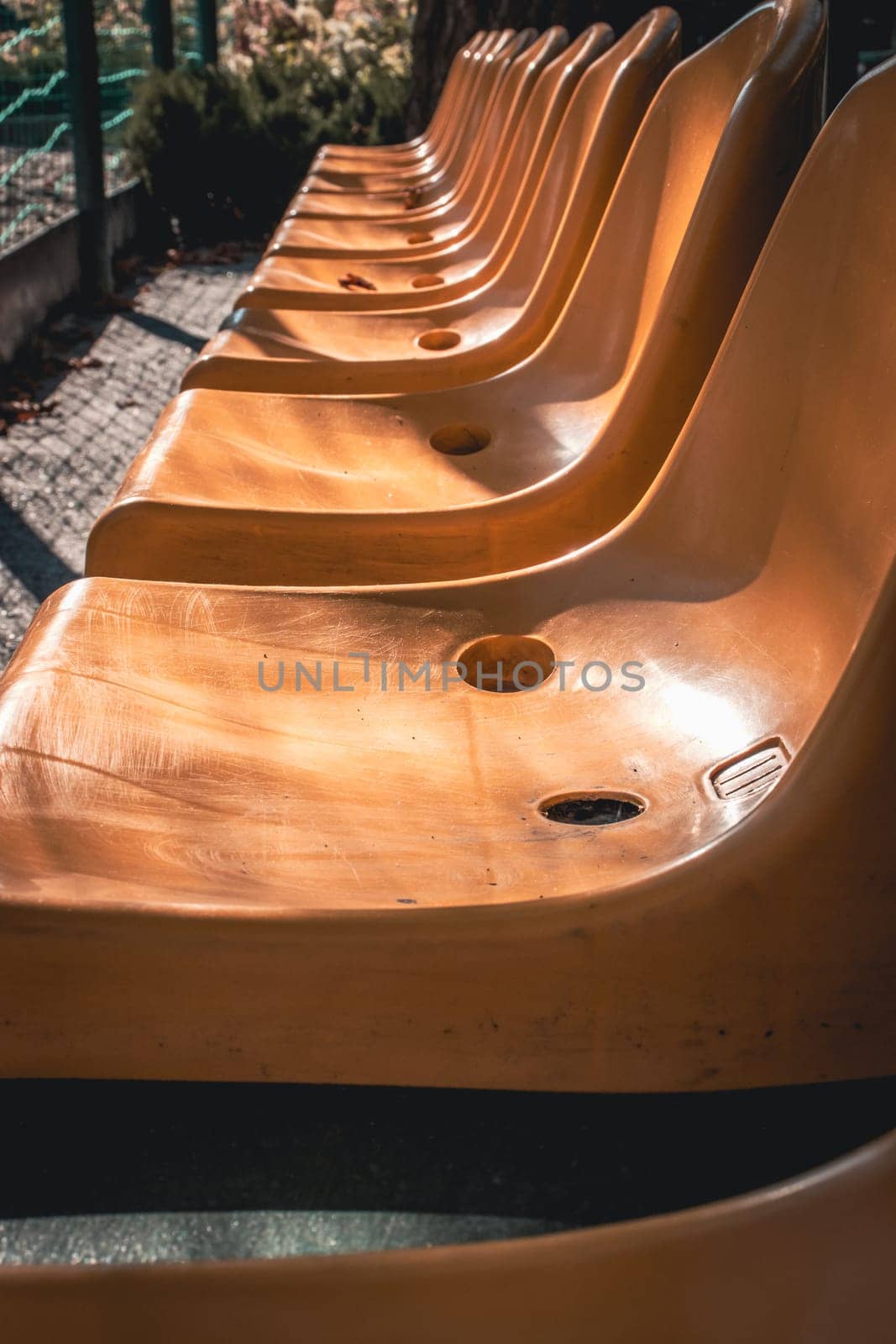 Close up yellow seats of tribune in public park concept photo. Chairs for audience in park. Cultural environment concept. Empty seats, modern stadium. High quality picture for wallpaper