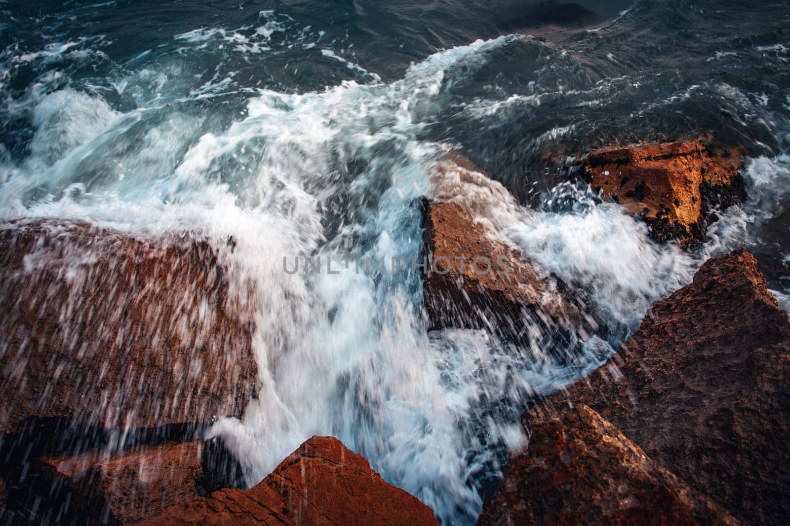 Close up water with stones on the beach concept photo. Stormy sea, waves, pebbles under water. The view from the top, nautical background. High quality picture for wallpaper