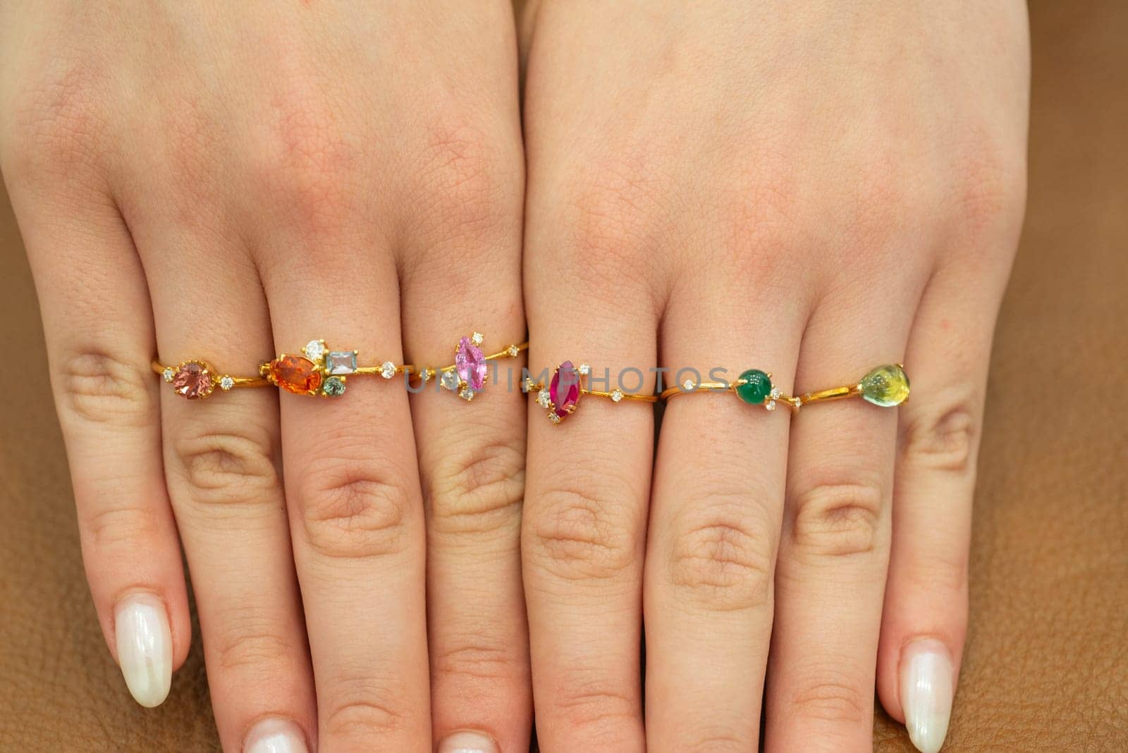 Selection of luxury expensive gold jewelry rings with gemstones on fingers of female womans hand
