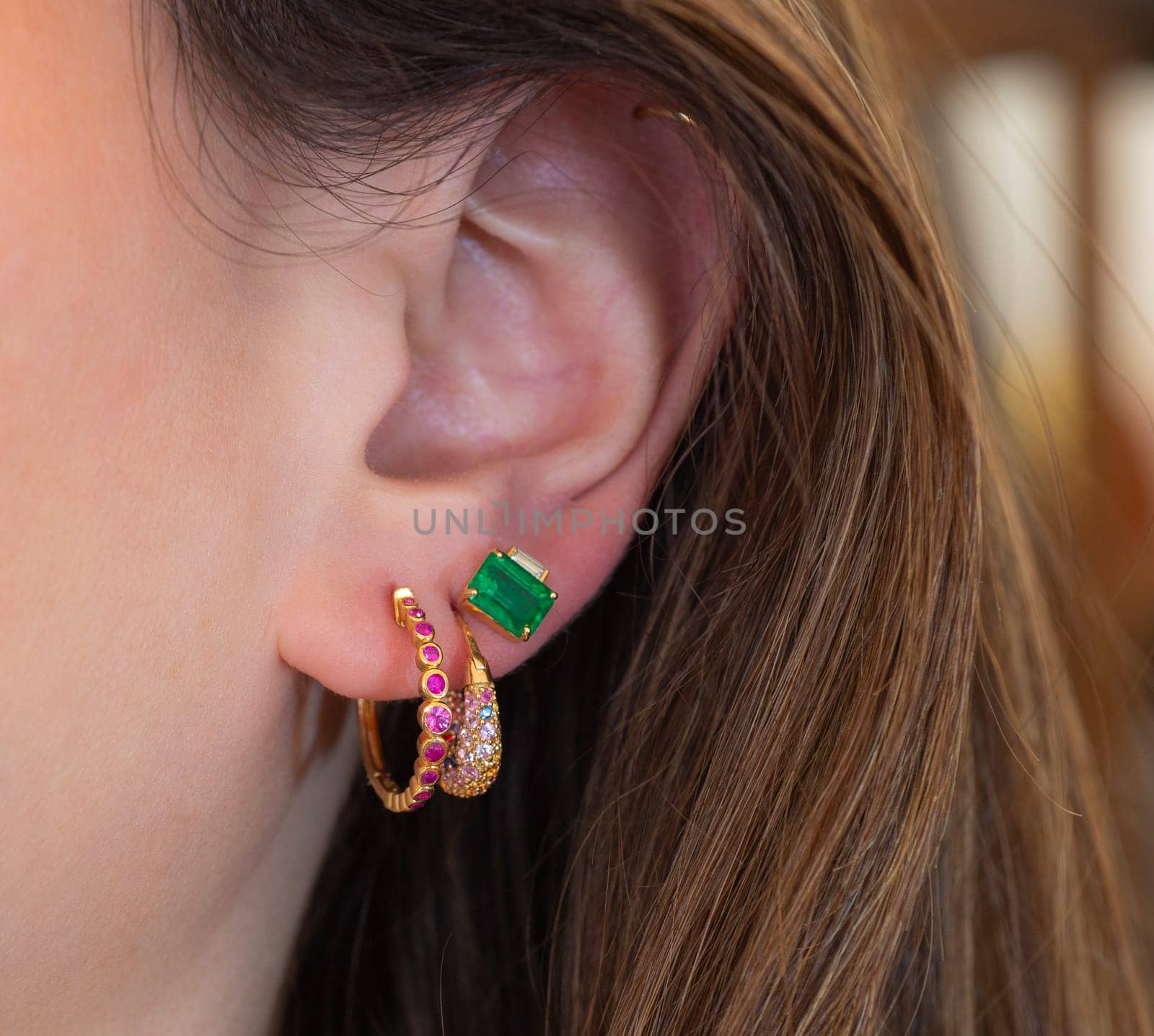 Closeup detail of ladies female ear with luxury expensive earrings and precious gemstones