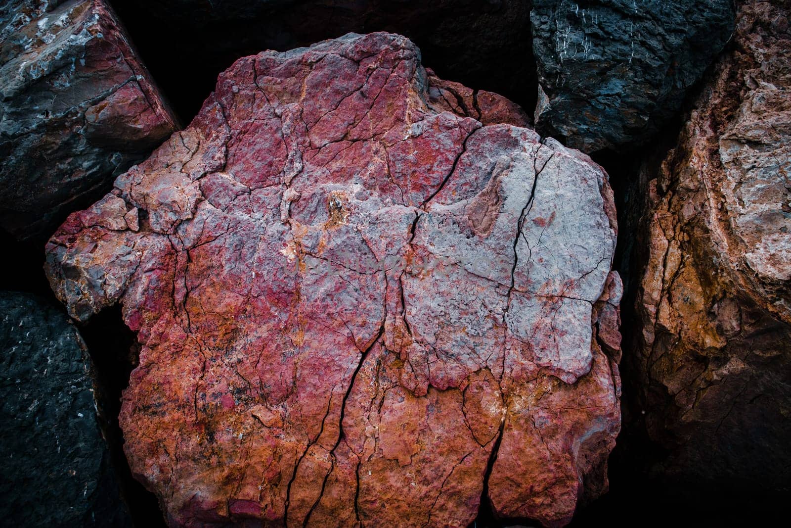 Red seaside rock texture concept photo. Mountain rough surface. Wide banner. Panoramic Mediterranean bright close up stones. High quality picture for wallpaper, travel blog