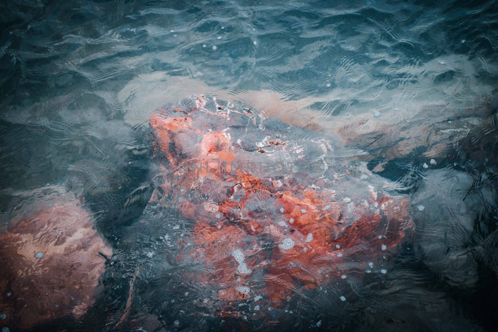 Close up underwater stone on the beach concept photo. Mediterranean winter sea. Pebbles under water. The view from the top, nautical background. High quality picture for wallpaper