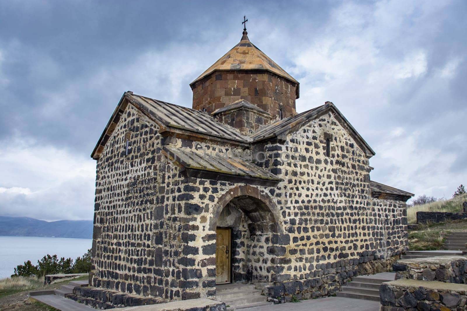 Monastery under dramatic spring sky photo. Ancient church near lake by _Nataly_Nati_