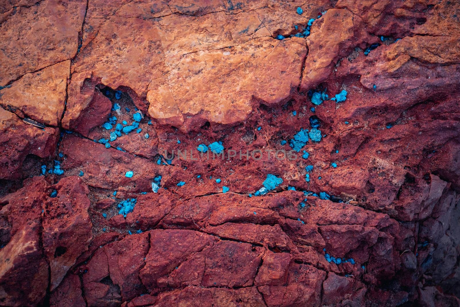 Red rough textured rock background photo. Close-up blue scattered in the stone. Sandstone background with copy space for design. Wide banner. High quality picture for wallpaper