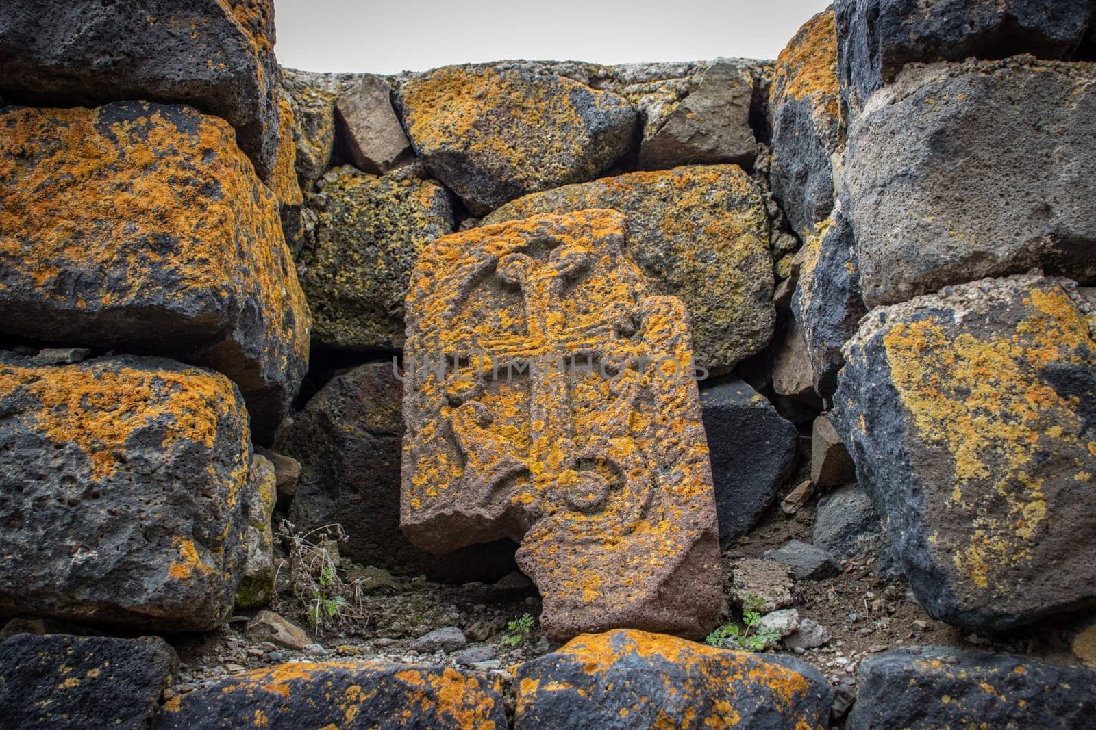 Close up stone cross with yellow lichen on rough stone wall concept photo. by _Nataly_Nati_