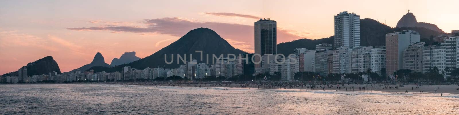 Dusk at Copacabana Beach with golden hues, Christ the Redeemer and mountain silhouettes
