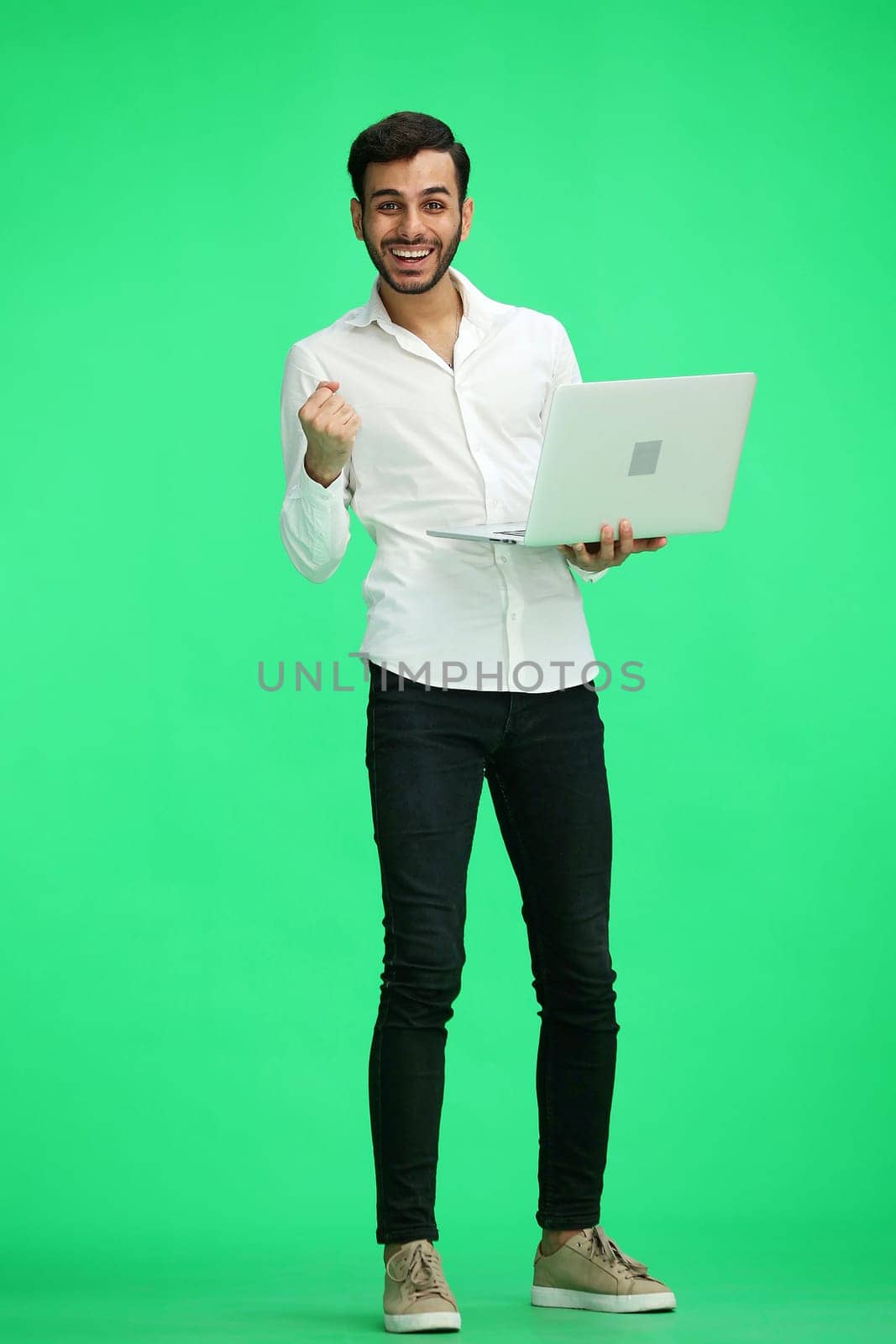 man on a green background. uses a computer.