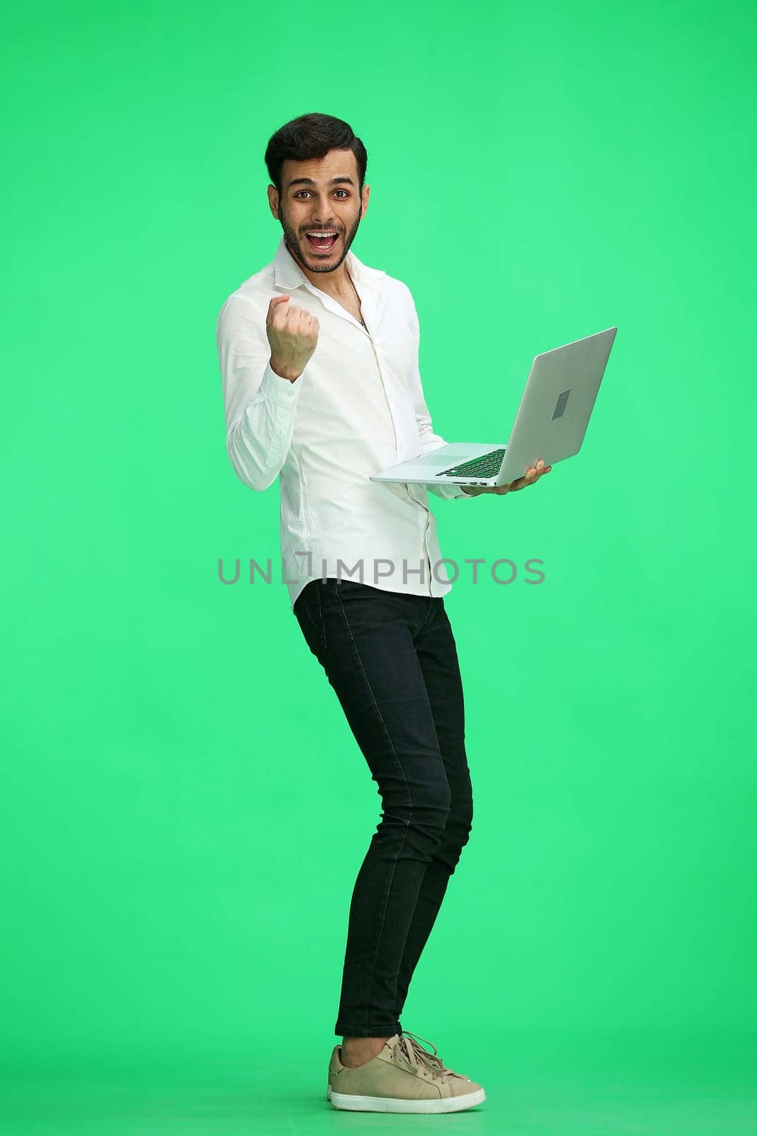 man on a green background. uses a computer.