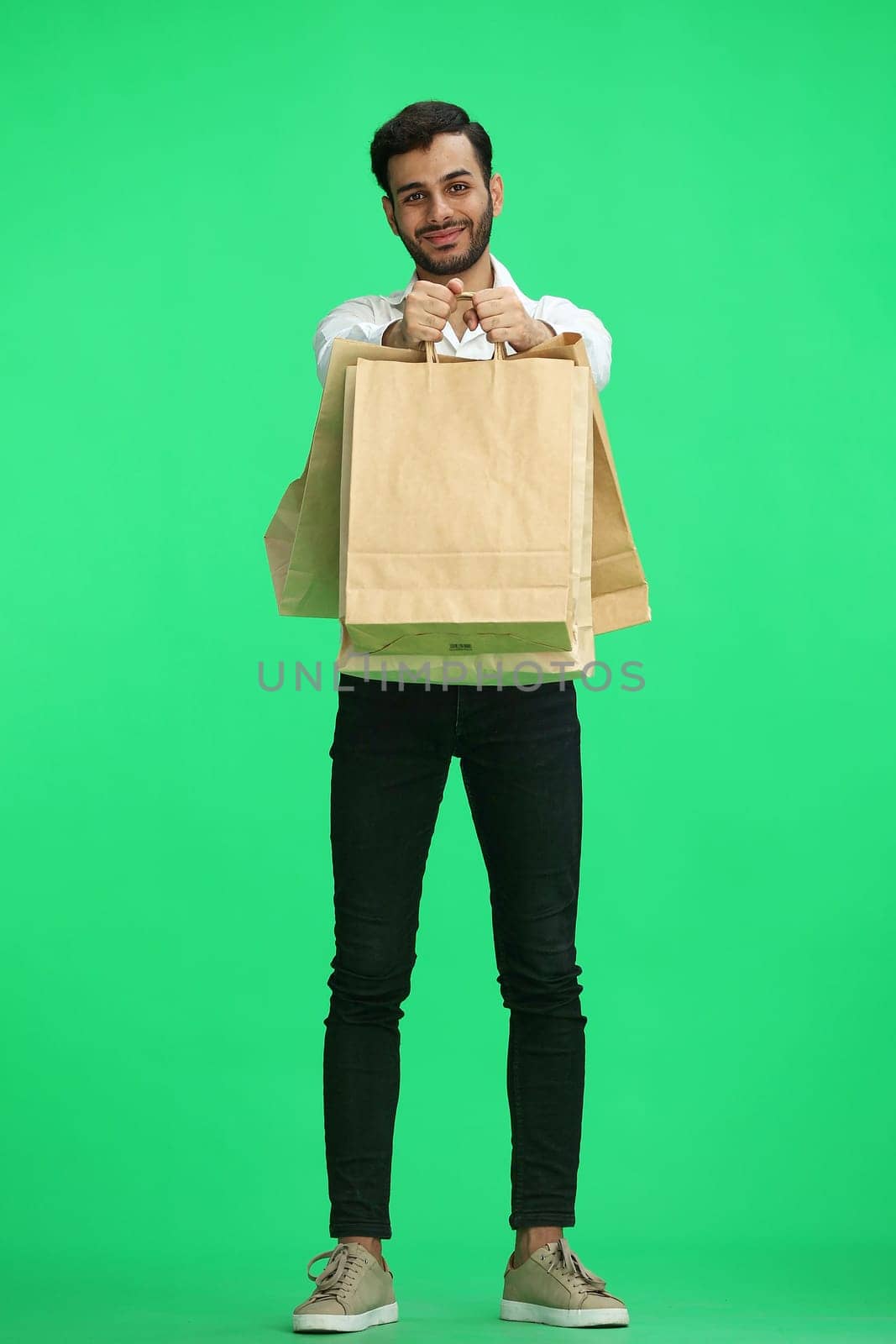 Man on a green background with shoppers by Prosto