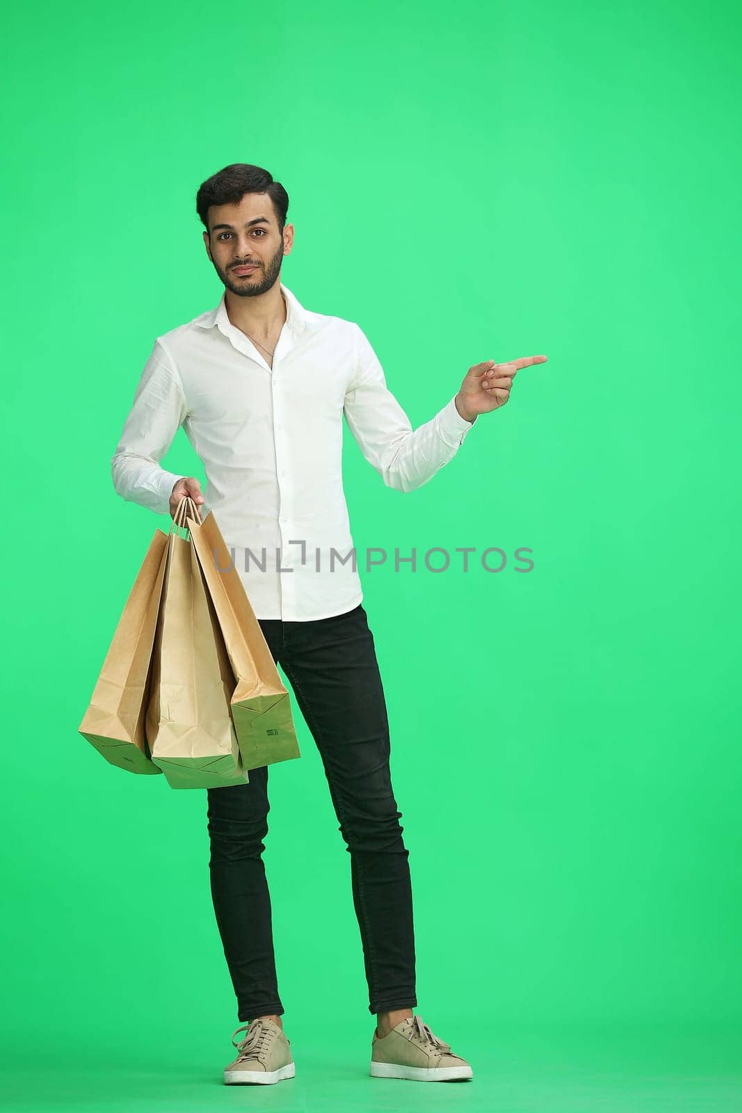 Man on a green background with shoppers point side by Prosto