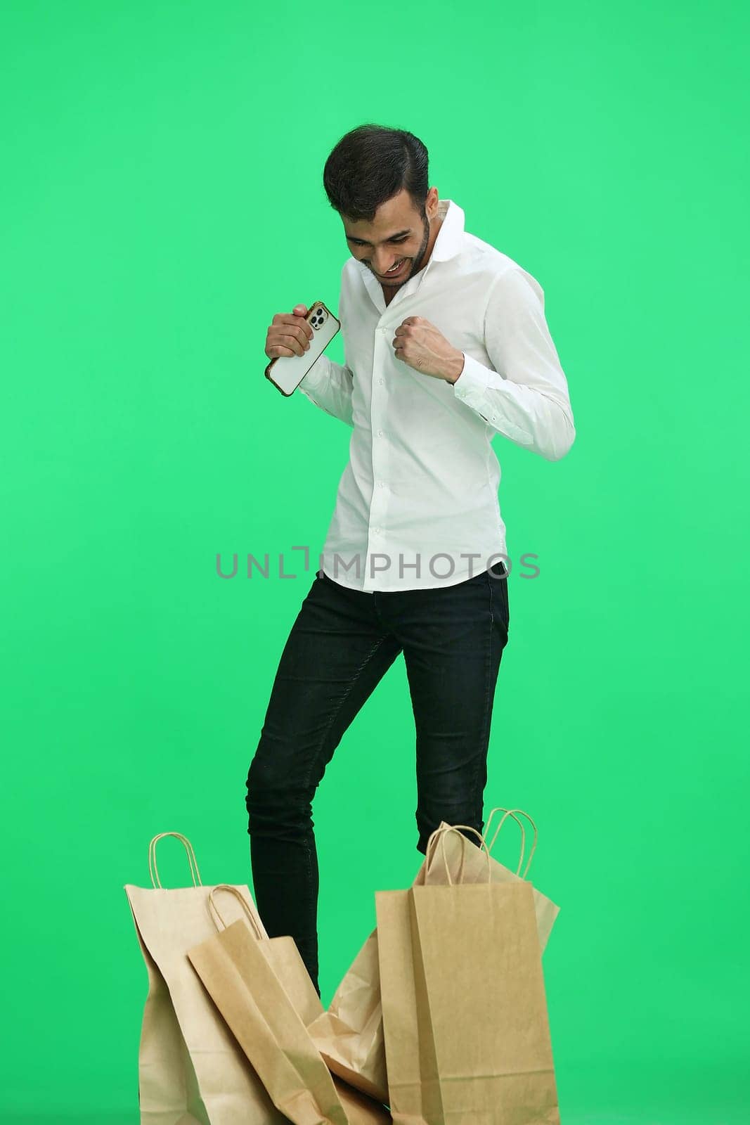 Man on a green background with shoppers.