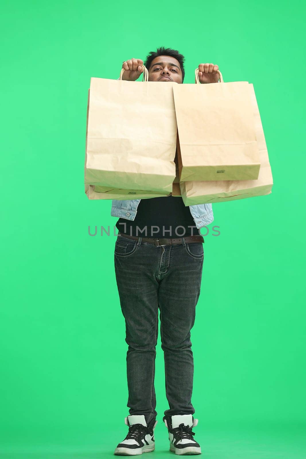 Man on a green background with shoppers by Prosto