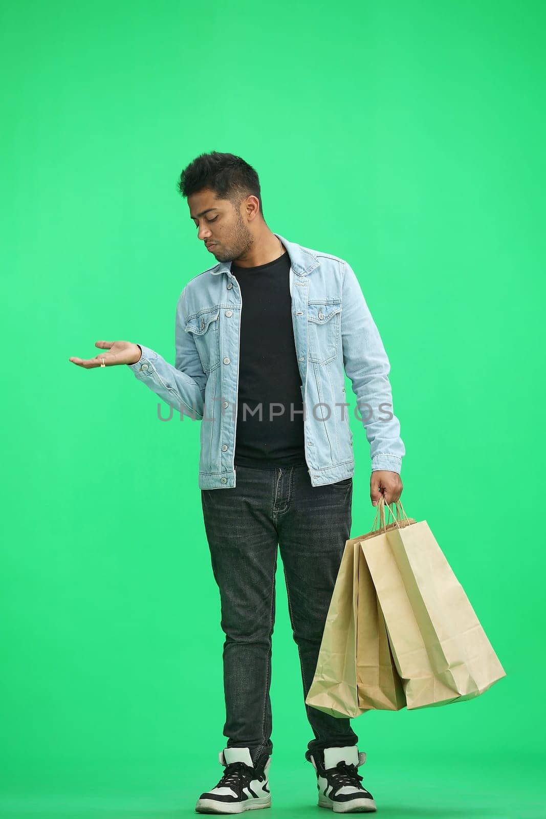Man on a green background with shoppers point side.
