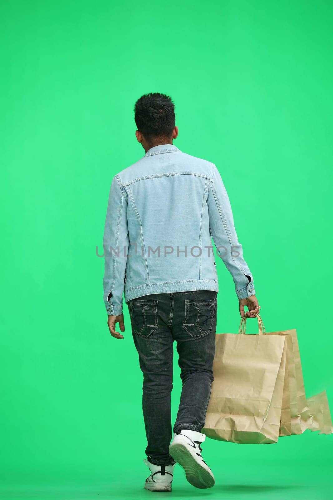 Man on a green background with shoppers.